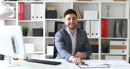 Regisseur sitzt im Weißen Büro, lächelt und führt Interview