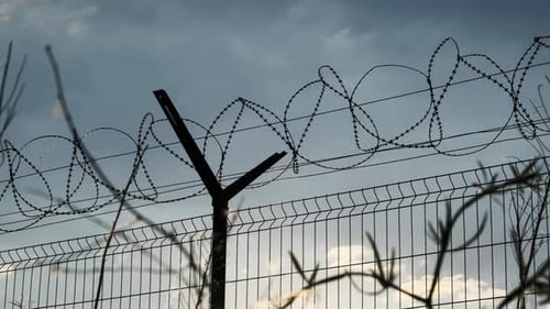Razor Wire on the Fence Against the Sunset Bottom View