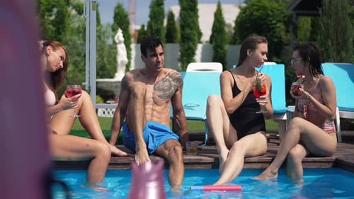 Friends Enjoying Drinks by a Swimming Pool on Summer Day
