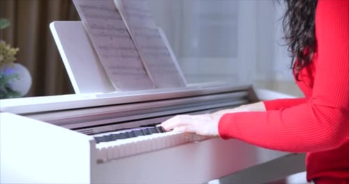 Woman Plays Piano with Sheet Music Close Up