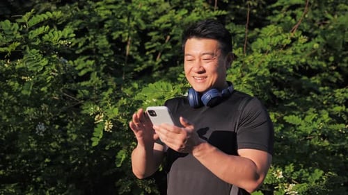 Man Smiling Using Mobile Phone Outdoors
