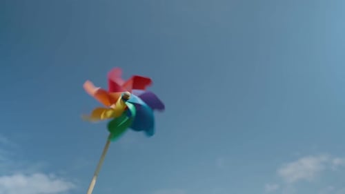 Moulin à vent en papier coloré contre le ciel bleu