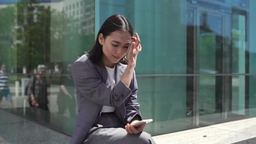 Woman Using Smartphone Outside in City Setting