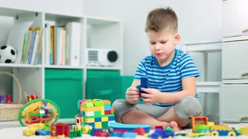 Young Boy Plays with Colorful Building Blocks at Home