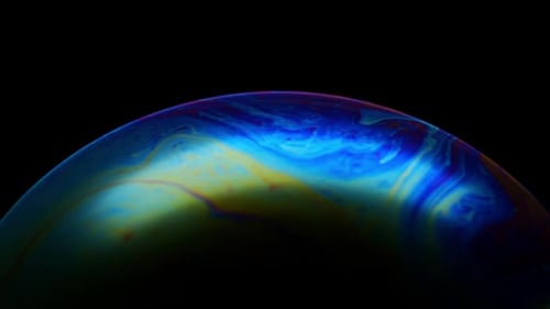 Seifenblase. Mehrfarbige Regenbogeniris wie ein fantastischer bunter Planet auf schwarzem Hintergrund