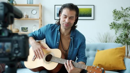 Man Playing Guitar Recording Video in Living Room