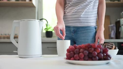 Young Adult Enjoys Grapes, Donut and Beverage