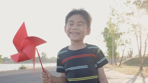 Asian child boy playing with pinwheels