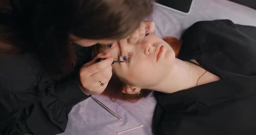 Lashmaker realiza el procedimiento de laminación de pestañas para el cliente en los servicios de cosmética del salón de belleza