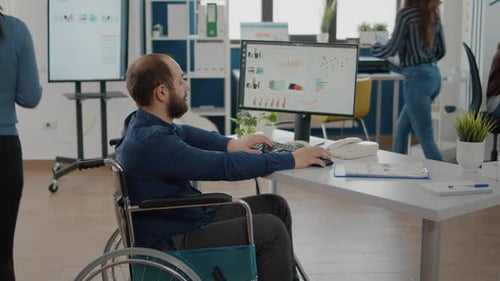 Man in Wheelchair Working in Modern Office