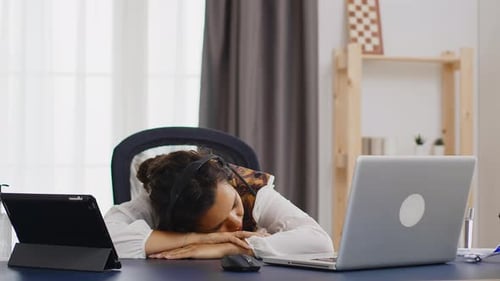 Tired Woman Working From Home Sleeping on the Desk