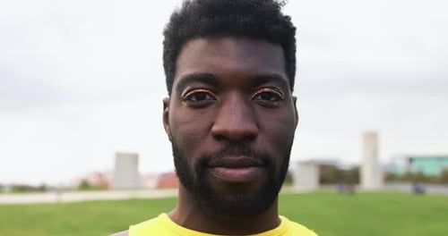 Young gay african man with make looking at camera at city park