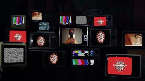 Pile of Retro Televisions Flashing Content in the Dark