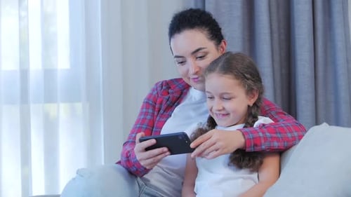 Mother and Child Watching a Phone Together at Home