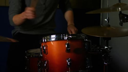 Drummer Playing Drums in Dark Studio