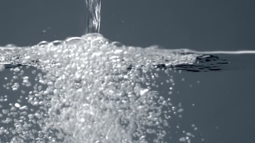 Sauberes Wasser in einem transparenten Aquarium mit Wasser gießen. Spritzwasser, Blasen, Zeitlupe ab 60