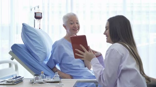 Senior Woman Video Calling with Tablet in Hospital Bed