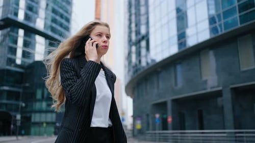 Business Woman Speaking Mobile Phone Onthe Go to Office Outdoors
