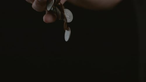 Hand dropping coins in slow motion; shot on Phantom Flex 4K at 1000 fps