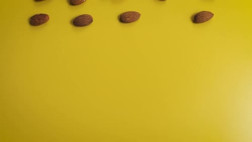 Almond Seeds Forming the Word Nut on a Yellow Background