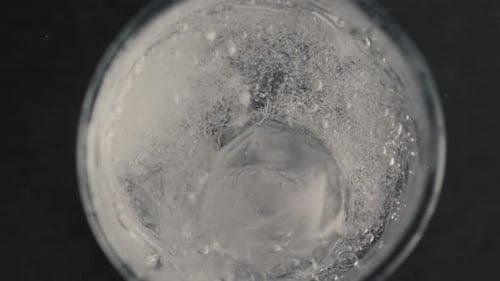 Fizzing Soda Water with Ice Cubes in Glass
