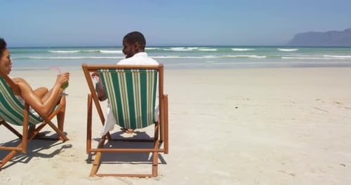 Couple toasting glasses of cocktails at beach 4k