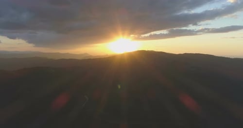 Große graue Wolken über dem warmen gelben Sonnenuntergang in den Bergen
