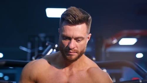 Handsome man with big muscles, posing on the camera in the gym. Slow motion.