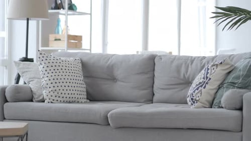 Man Stands Up and Walks Away From Couch