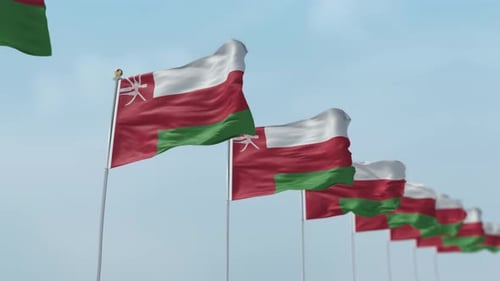 Oman Flags Waving in Wind Against Blue Sky