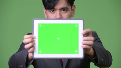 Young Adult Holding Tablet with Green Screen