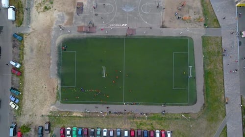 Vista aérea sobre un campo de fútbol, equipos jugando al fútbol, en un barrio pobre y pobre de Kiev, nuboso