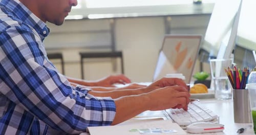 Two People Working on Computers in Office