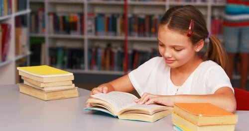 Schoolgirl reading book in library