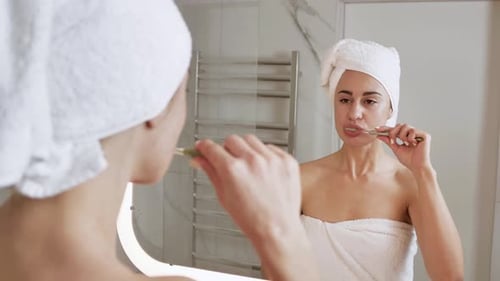 Woman Brushing Teeth in Modern Bathroom