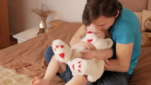 Caring Father Brushing Daughter's Hair in Bedroom