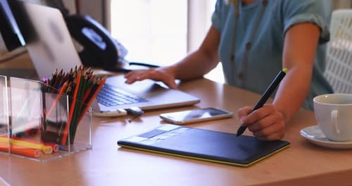 Female executive working over graphic tablet at her desk 4k