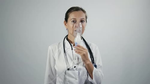 Une femme médecin montre un nébuliseur sur son visage