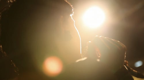 Singer Performing Backlit on Stage at Night