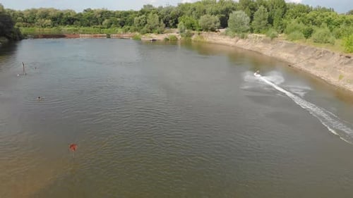 Mann auf Jetski fährt schnell mit viel Spritzern auf dem Fluss