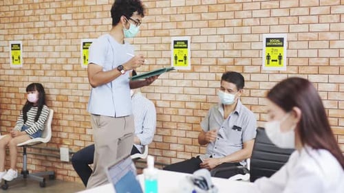 People Wearing Masks Wait in Medical Clinic