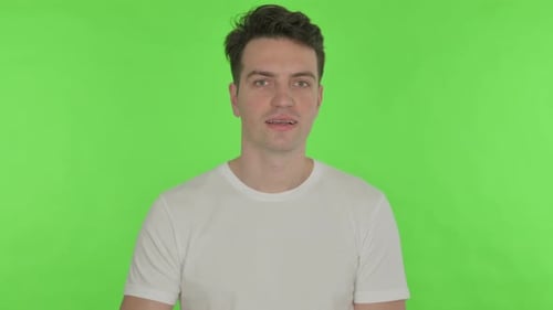 Thumbs Up By Young Man on Green Background