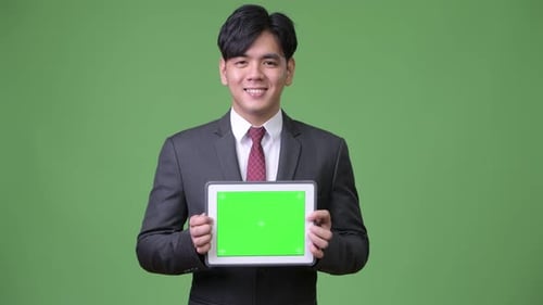 Man in Suit Holding Tablet with Green Screen