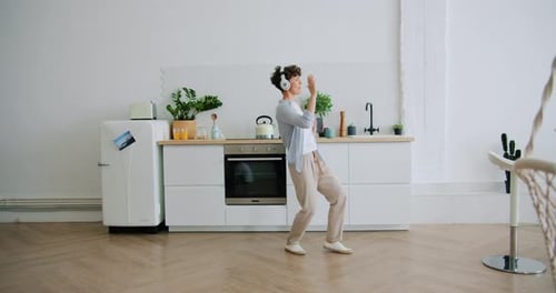 Young Adult Dancing to Music in Kitchen