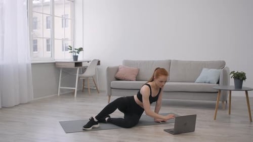 Woman Exercises at Home with Laptop