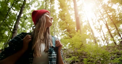Rucksack Frau blickt auf Bäume im Wald
