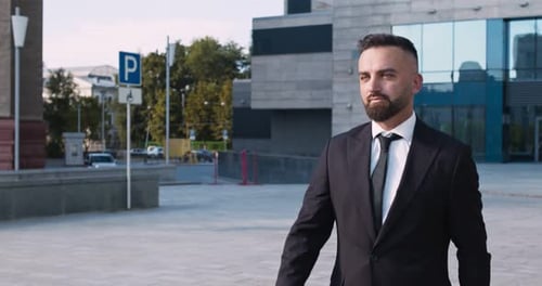 Portrait en extérieur d'un homme d'affaires confiant marchant dans un quartier d'affaires, Ralenti