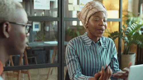 Black Woman Discussing Business with Coworker at Office Meeting