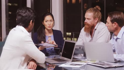 Four Adults Talking in a Night Office Meeting