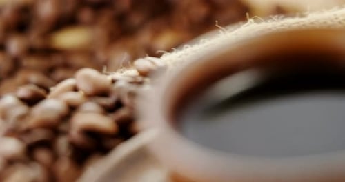 Coffee Beans and Cup of Steaming Black Coffee